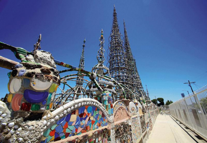 Les Watts Towers, de Sabato Rodia (1875-1965), maçon italien, immigré en 1890 aux États-Unis. Situé dans le quartier de Watts, dans la banlieue de Los Angeles, cet ensemble est constitué de 9 tours dont la plus haute culmine à 33 m. L’auteur se servait de barres en métal qu’il courbait après les avoir glissées sous les rails d’une voie ferrée située à proximité, ainsi que de béton, recouvert de coquillages et de mosaïques en vaisselle cassée ou en verre.  Source : musée de Lausanne, photo Christina Czybik