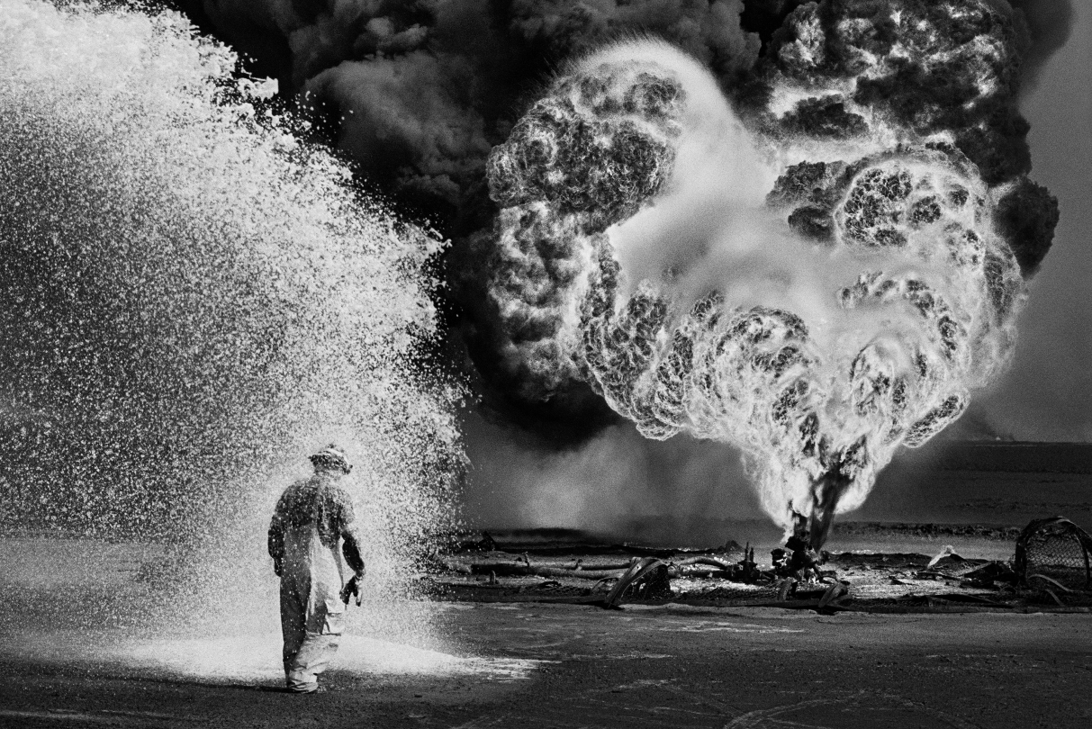 Ce combattant du feu est protégé de la température extrême des flammes par la vaporisation diffuse de produits chimiques. Puits de pétrole, Burhan, Koweit, 1991
